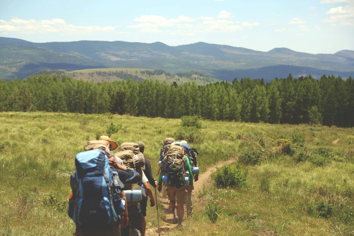 A group hiking with backpacks through open hills